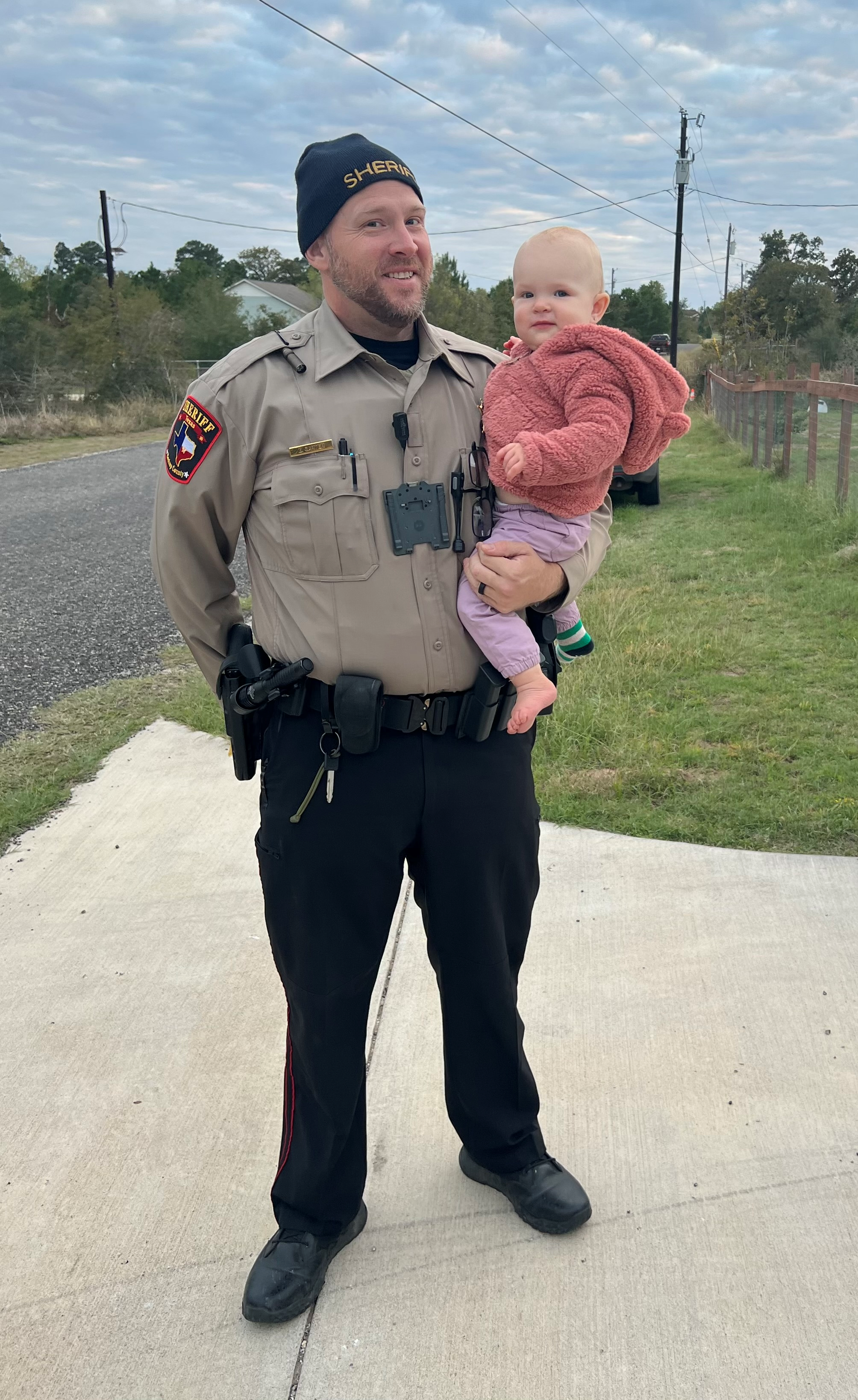 Zachary Carter in sheriff uniform with his child